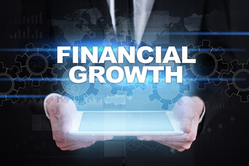 Businessman holding tablet PC with financial growth concept.