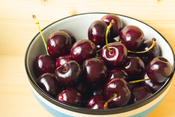 Close up fresh cherries in bowl on table