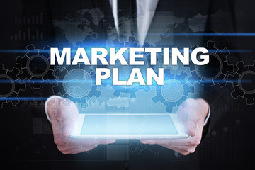 Businessman holding tablet PC with marketing plan concept.