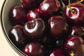 Close up fresh cherries in bowl on table