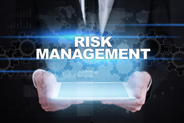 Businessman holding tablet PC with risk management concept.