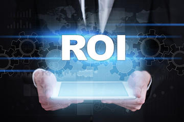 Businessman holding tablet PC with roi concept.