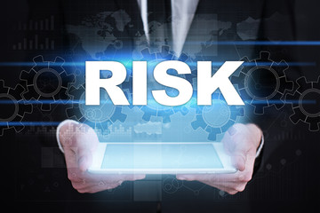 Businessman holding tablet PC with risk concept.