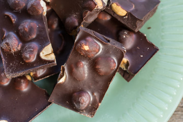 Chocolate and nuts chunks on green plate