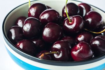 Close up fresh cherries in bowl on table