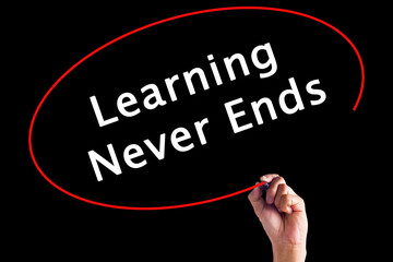 Hand Writing Learning Never Ends with a marker over transparent board.