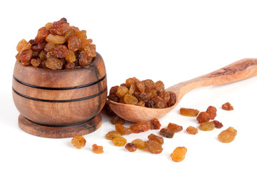 raisins in a wooden bowl with spoon isolated on white background. Selective focus