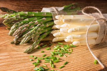 Green and white asparagus on wood