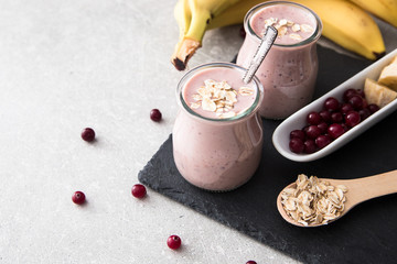 Smoothie of banana and cranberries with yogurt and oats on an slate Board