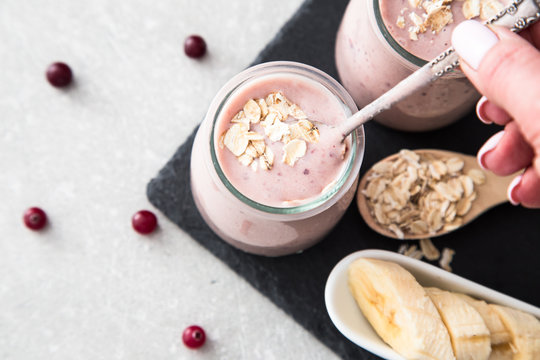 Smoothie of banana and cranberries with yogurt and oats on an slate Board