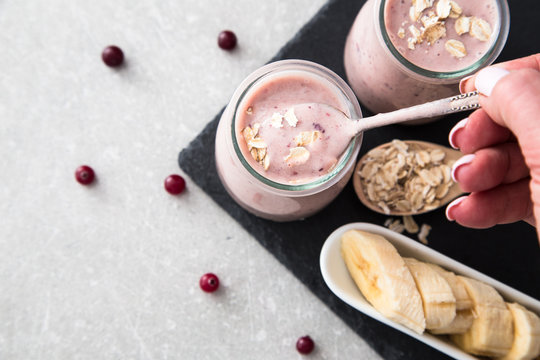 Smoothie of banana and cranberries with yogurt and oats on an slate Board