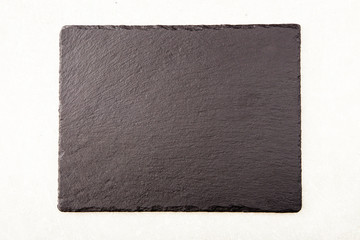 Textured slate board for dishes on light background