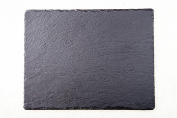 Textured slate board for dishes on light background