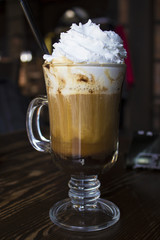 Coffee cappuccino in a glass cup on wooden table