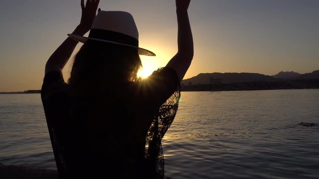 Woman Puts on Hat and Starts Dancing on Sunset