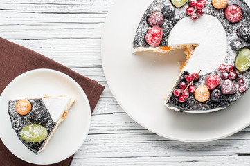 chocolate berry cake on plate over white wooden background