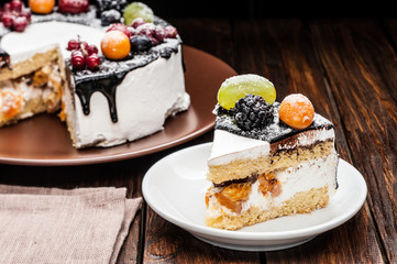 chocolate berry cake slice on plate over brown wooden background