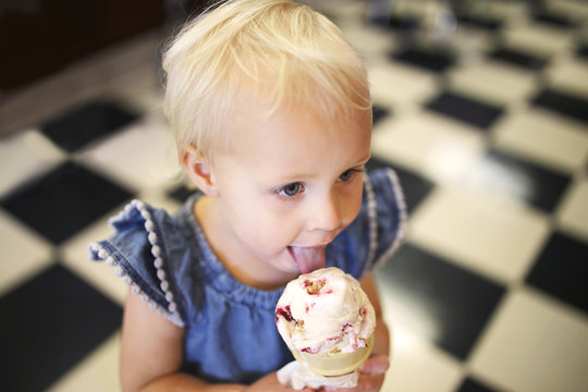 Little Girl Eating Ice Cream Cone In Old Fashioned Candy Shop