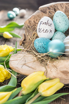 T&uuml;rkisfarbene Ostereier und gelbe Tulpen