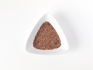 White bowl of flaxseed on white background. Healthy food ingredient
