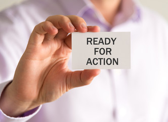 Businessman holding a card with READY FOR ACTION message