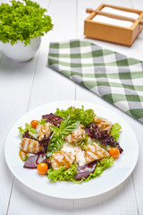 Warm salad with grilled turkey, roasted beet, salad, kumquat and melted cheese. Low carb diet.