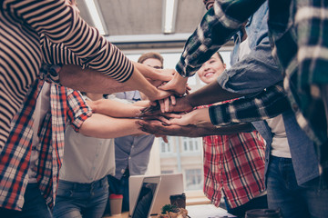 Close up of young team of managers holding hands together