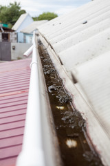 Dirty rain gutter on asbestos slate roof need to cleaning
