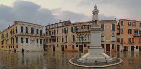 A statue is the focal point of a piazza or square on a rainy day in an often unseen part of Venice,...