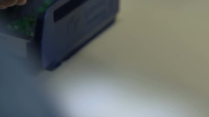 Worker Hands Holds Checks Green Chip at Bright Light Closeup