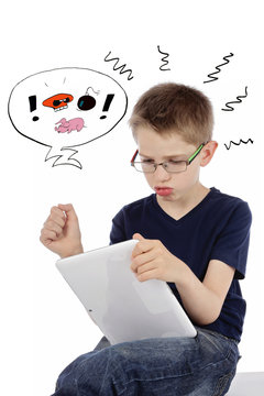 enfant r&acirc;lant en jouant sur une tablette informatique