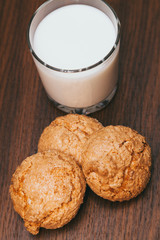 glass of milk and cookies on wooden background