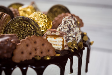 Chocolate cupcakes, decorated with candy,cookies and candy bars.Top view. tasty cake,colorful cream, wooden background,close up,dessert concept,Birthday cake