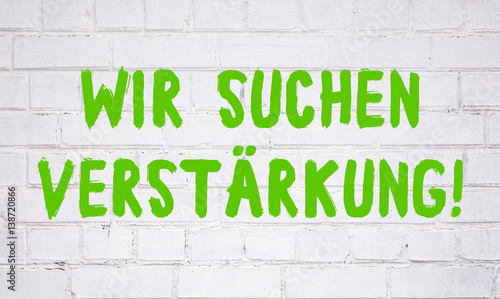 "Wir suchen Verstärkung! Text auf weißer Steinwand ...