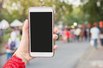 Hand holding Smartphone with blurred street background