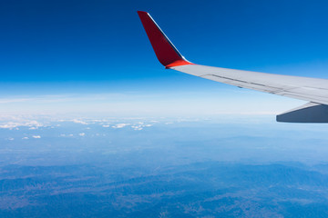 Wing of an airplane flying above the clouds