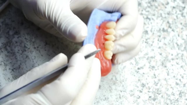 Closeup of a dental technician making of denture in a dental lab