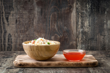 Fried chinese rice with vegetables on wooden background
