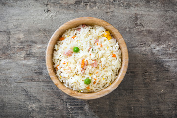 Fried chinese rice with vegetables on wooden background
