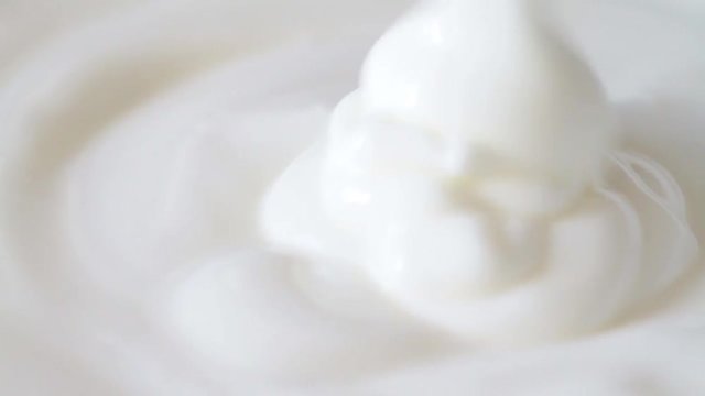 Pouring or mixing blending fresh natural yogurt, closeup. HD footage stock video.