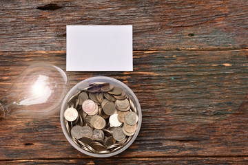 Obraz na płótnie Canvas White paper mock up,light bulb for idea and stack coins in glass put on hand for save money and financial, tax season