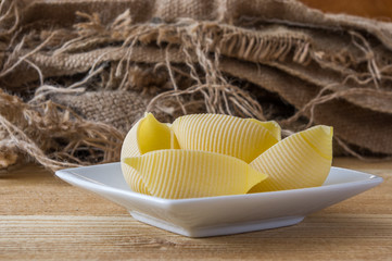 żółty makaron jajeczny muszelki na drewnianym stole © Krzysztof Matloch