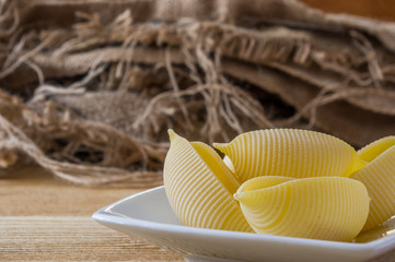 żółty makaron jajeczny muszelki na drewnianym stole © Krzysztof Matloch