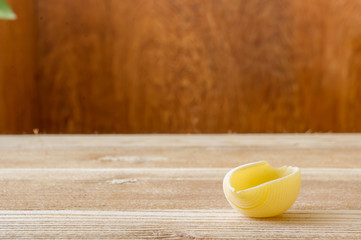 żółty makaron jajeczny muszelki na drewnianym stole