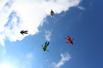 Skydivers are flying in the blue sky