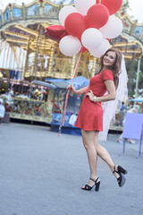 beautiful bride with balloons in the park