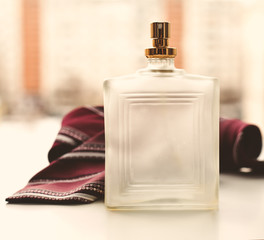 bottle of men's perfume with tie on a white background.