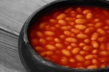 Baked beans in a wooden bowl with selective colour