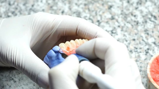 Closeup of a dental technician making of denture in a dental lab