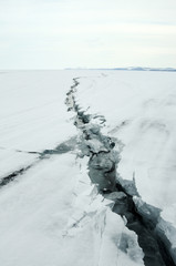 Ice hummocks on the northern shore of Olkhon Island on Lake Baikal. Fresh crack broke the thick ice. Fresh clean water rises from the depths and freeze in the cold. Ice Storm. Photo partially tinted